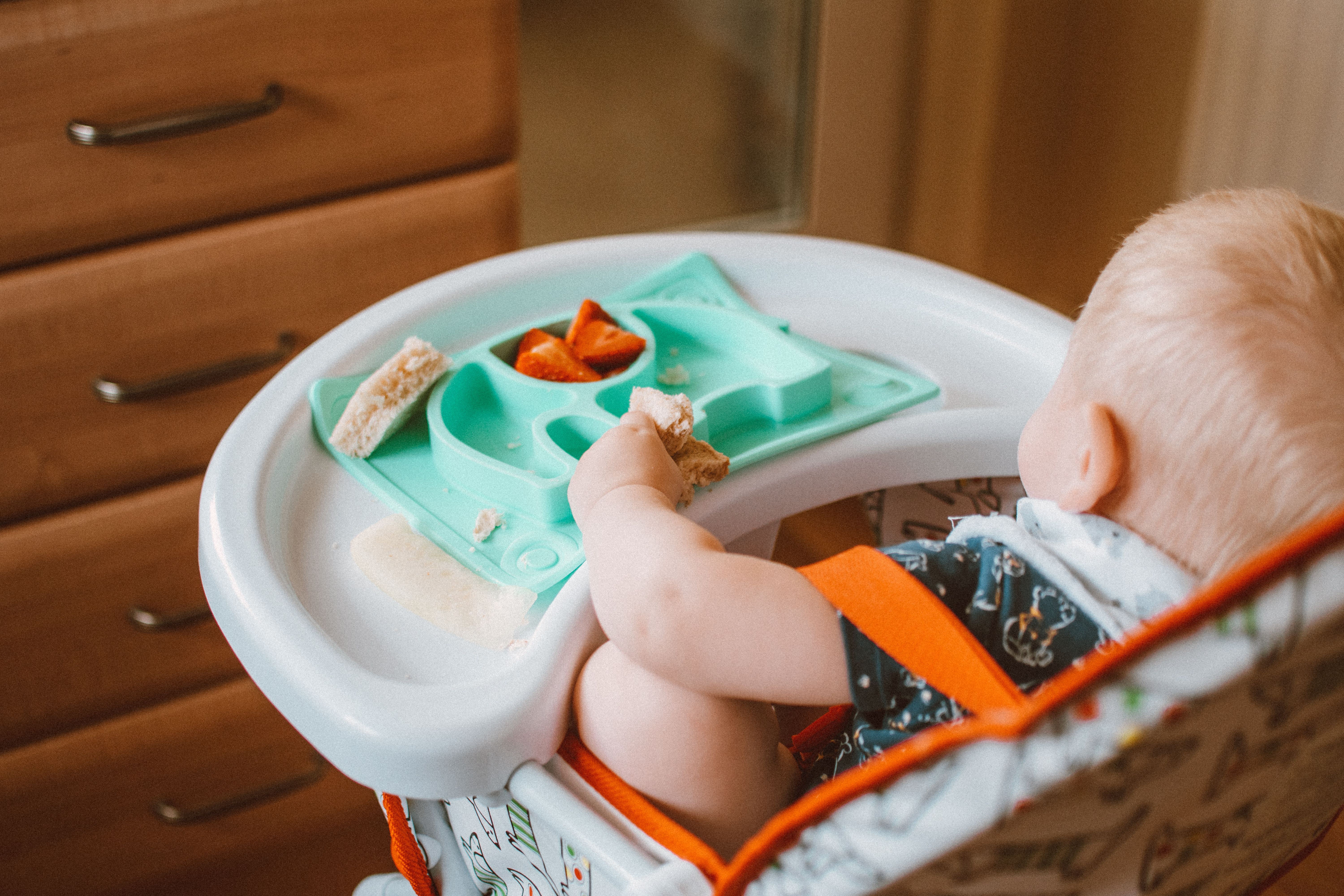 Bebê sentado em cadeira de alimentação em ambiente doméstico