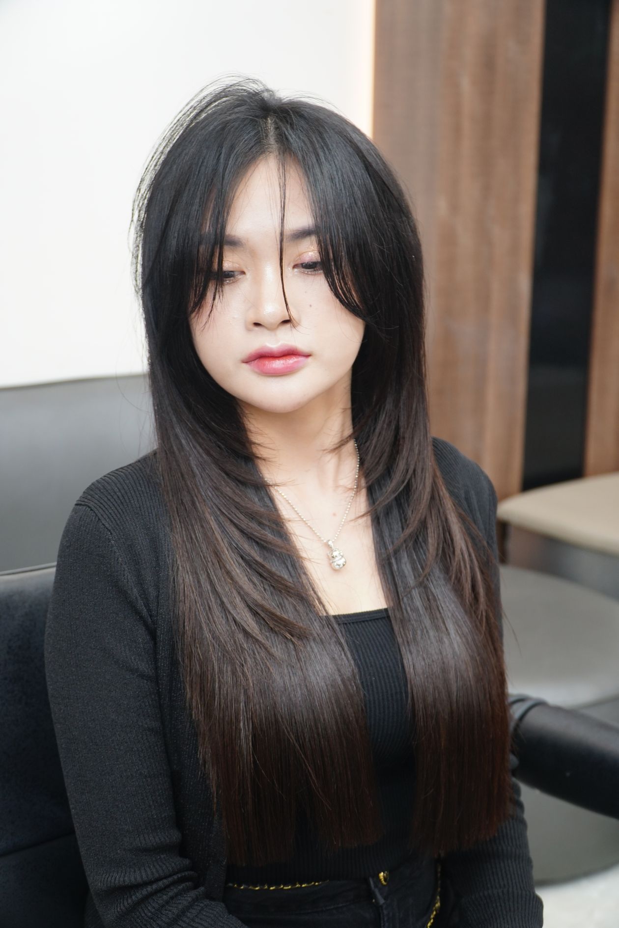 Mulher de cabelo liso longo em salão de beleza, contexto de alisante de cabelo