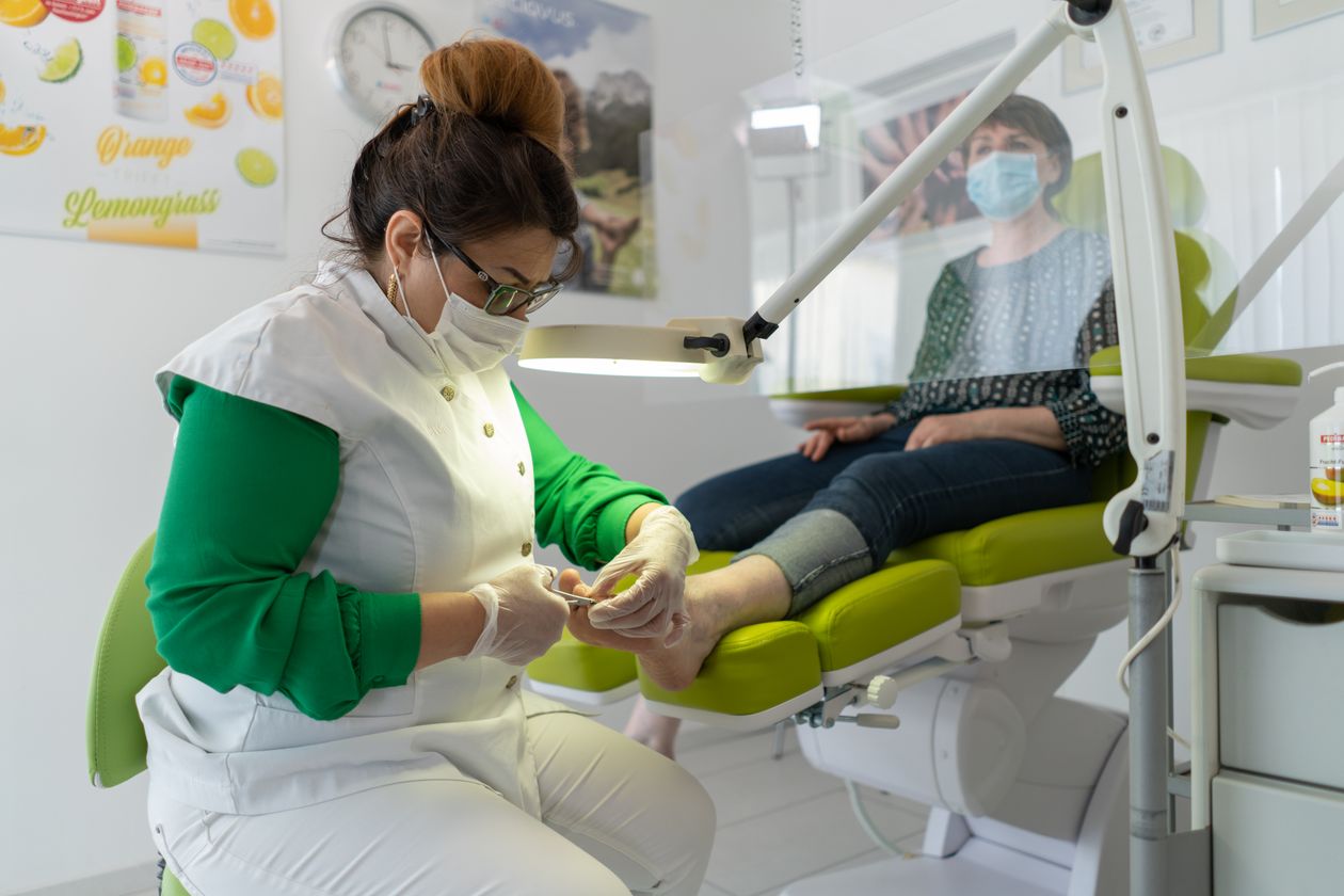 Pessoa cuidando das unhas dos pés em sessão de pedicure, contexto de antifúngico para unhas