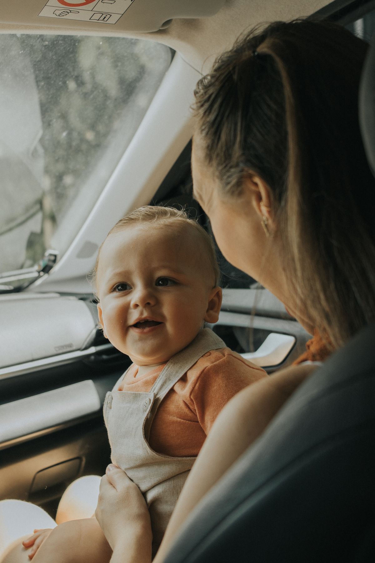 Mãe e bebê instalados no banco traseiro do carro - instalação do assento de elevação infantil