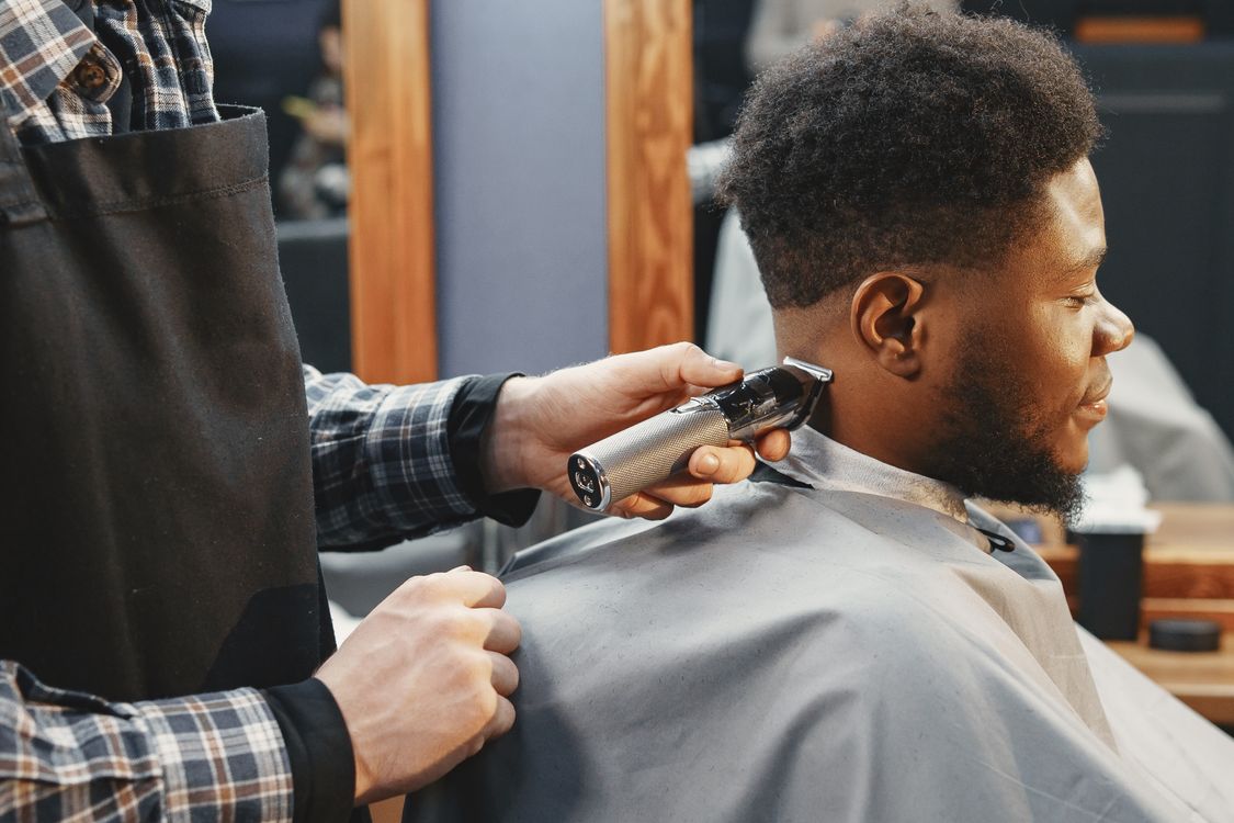 Barbeiro cortando cabelo com máquina profissional, contexto de máquina de cortar cabelo com fio