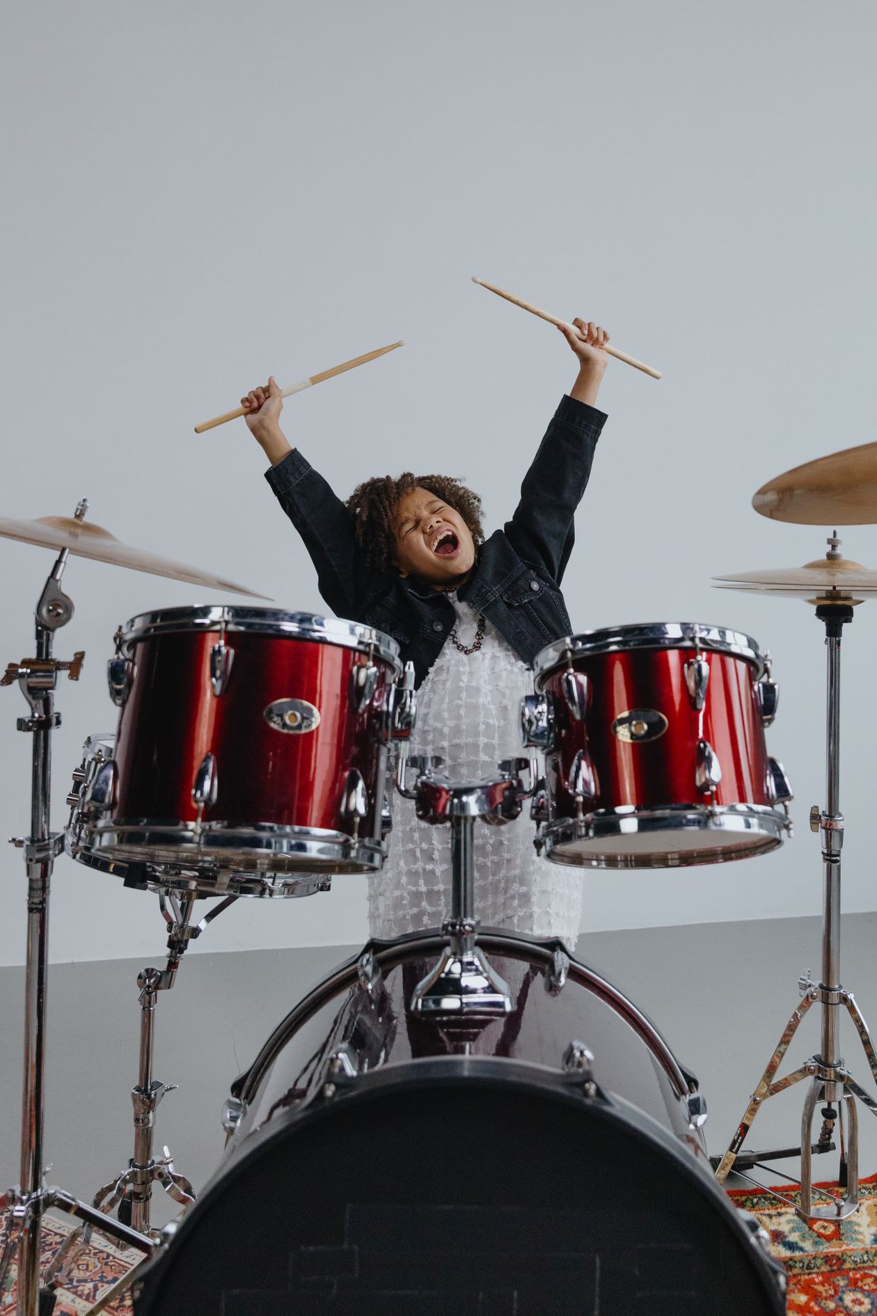 Criança tocando bateria de brinquedo, contexto de melhor marca de bateria infantil