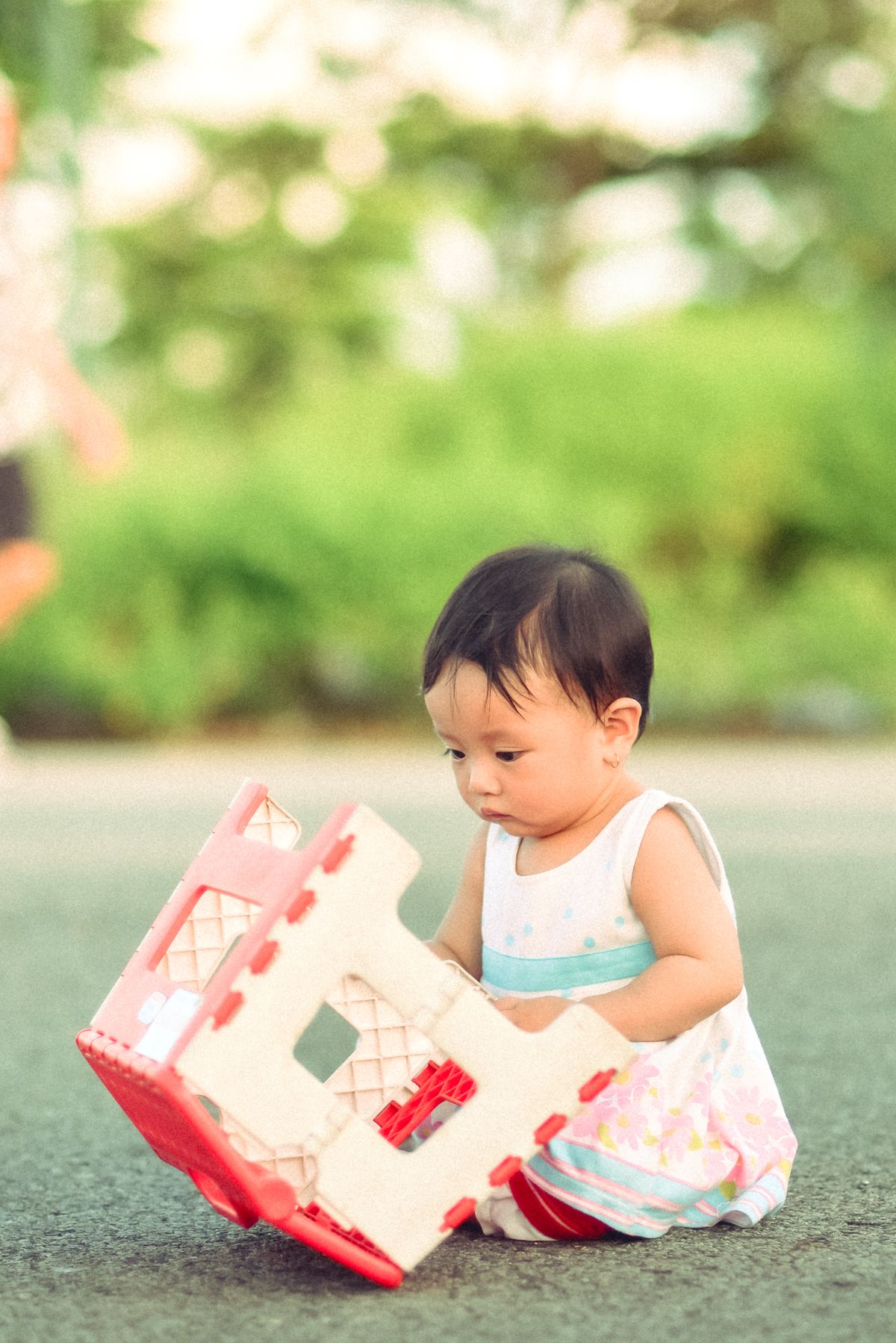 Bebê brincando com brinquedo ao ar livre em dia ensolarado - contexto de uso de bola para bebê