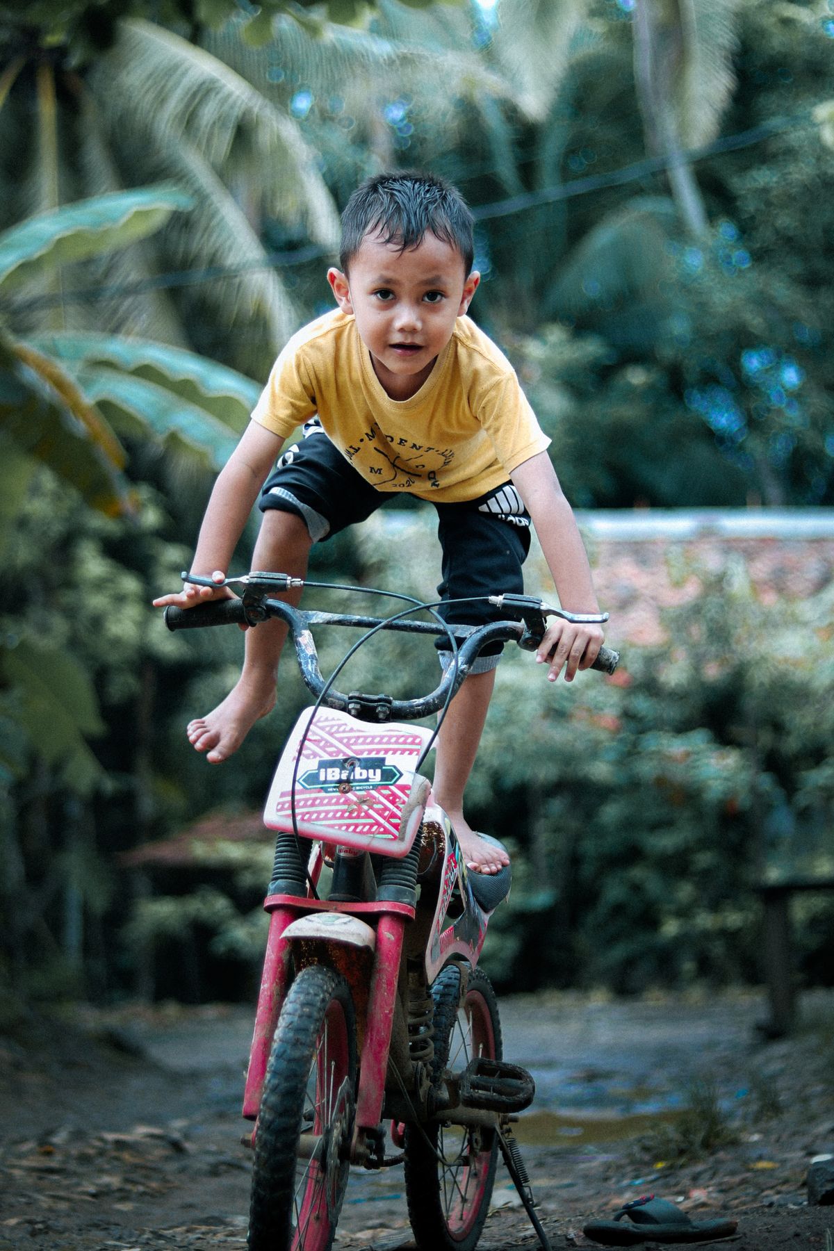 Crian�a fazendo acrobacia de bicicleta em parque - divers�o e aventura com a bicicleta