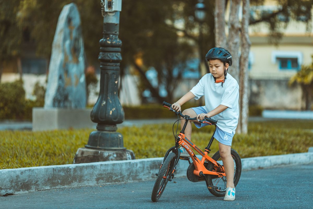Crian�a pedalando com confian�a ao ar livre - uso da bicicleta infantil na rua
