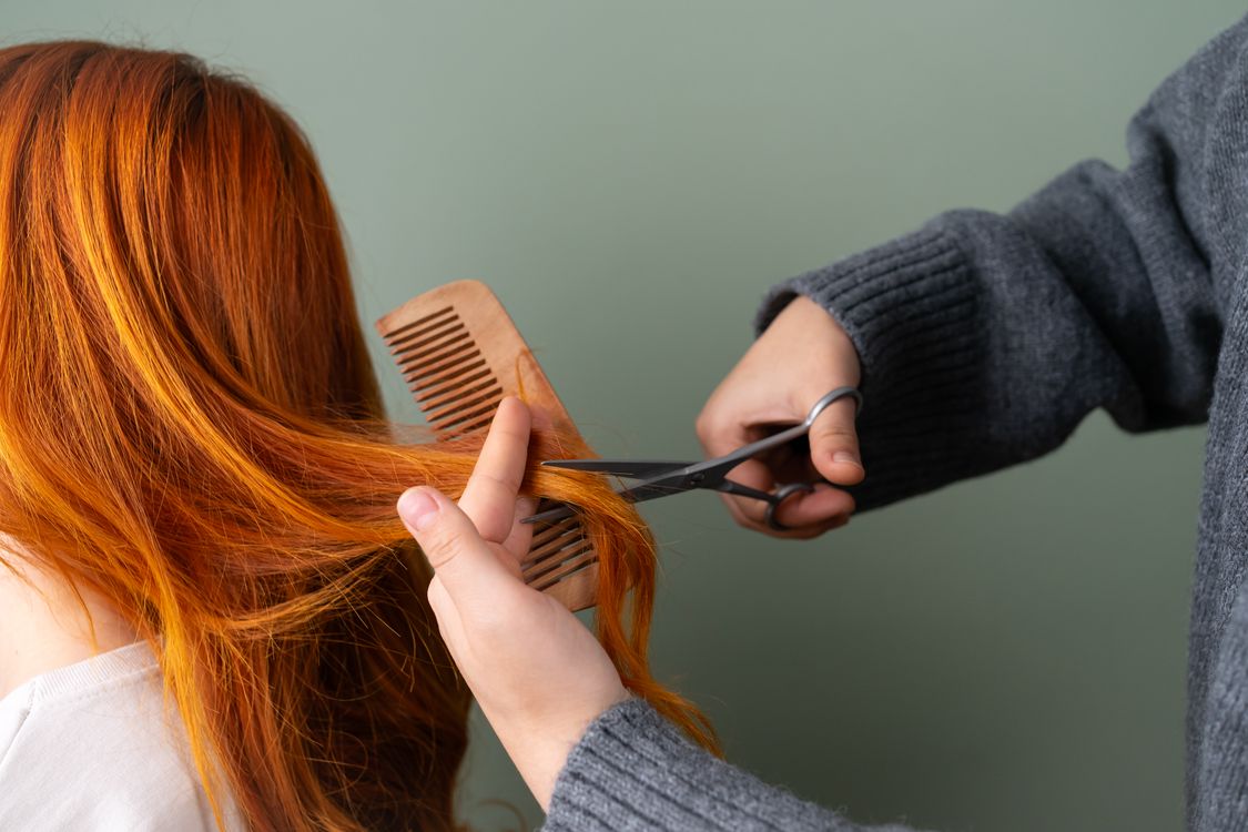 Cabeleireiro cortando cabelo com tesoura, contexto de precisão profissional