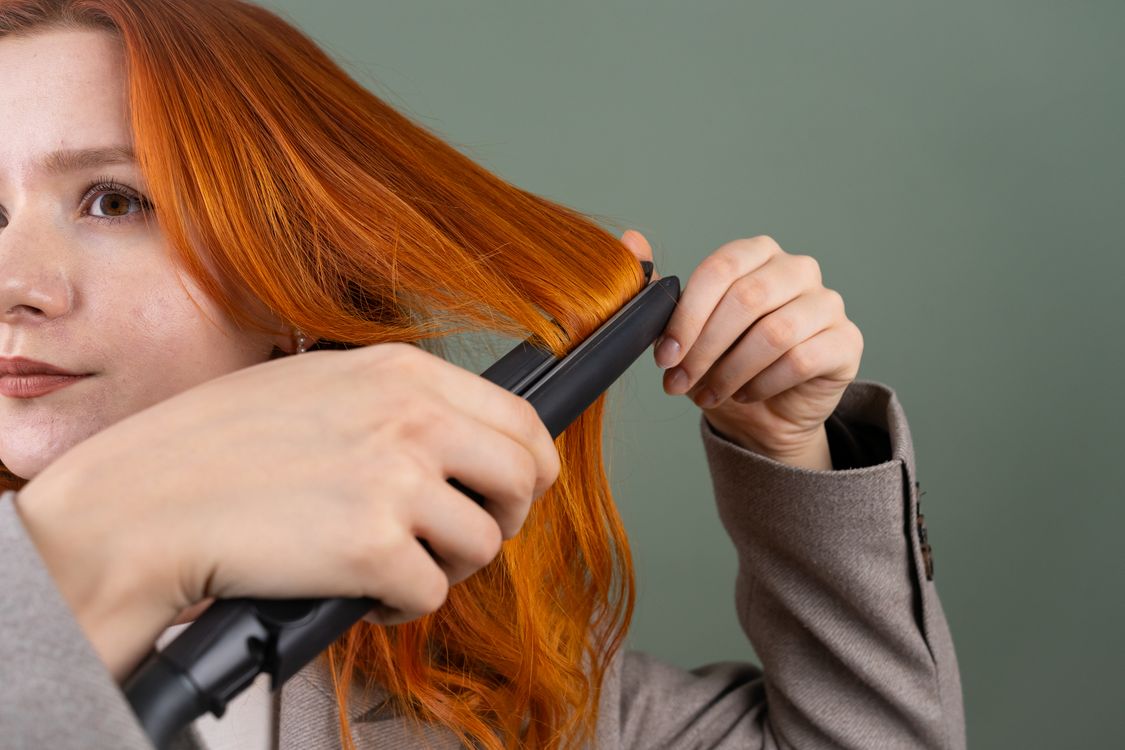 Mulher alisando o cabelo com chapinha, contexto de melhor marca de chapinha para alisar