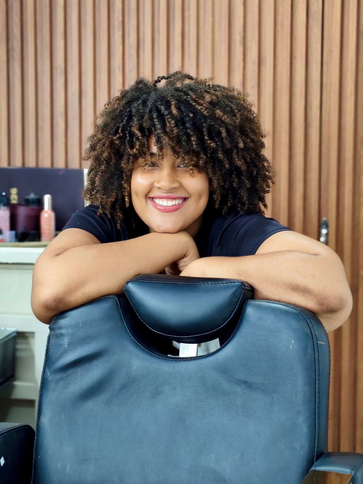 Mulher de cabelo cacheado sorrindo, contexto de cacheador de cabelo