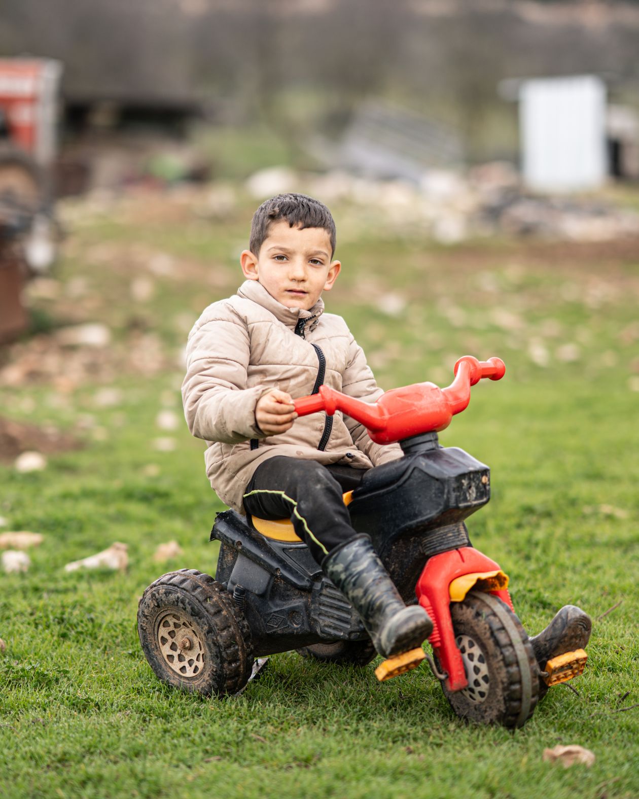 Criança andando em veículo de brinquedo ao ar livre, contexto de melhor carrinho elétrico infantil usado