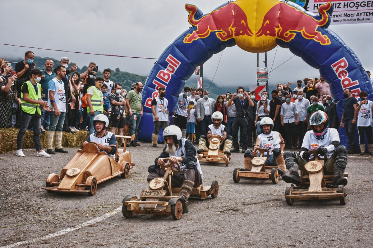 Carrinhos de rolimã de madeira em corrida, contexto de uso do brinquedo em competição ao ar livre