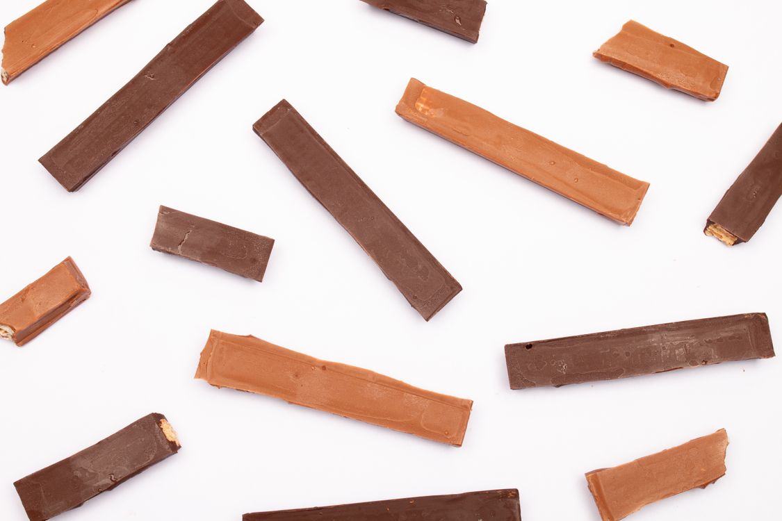 Barras de chocolate ao leite e blend em flat lay, contexto de escolha entre chocolate ao leite ou blend