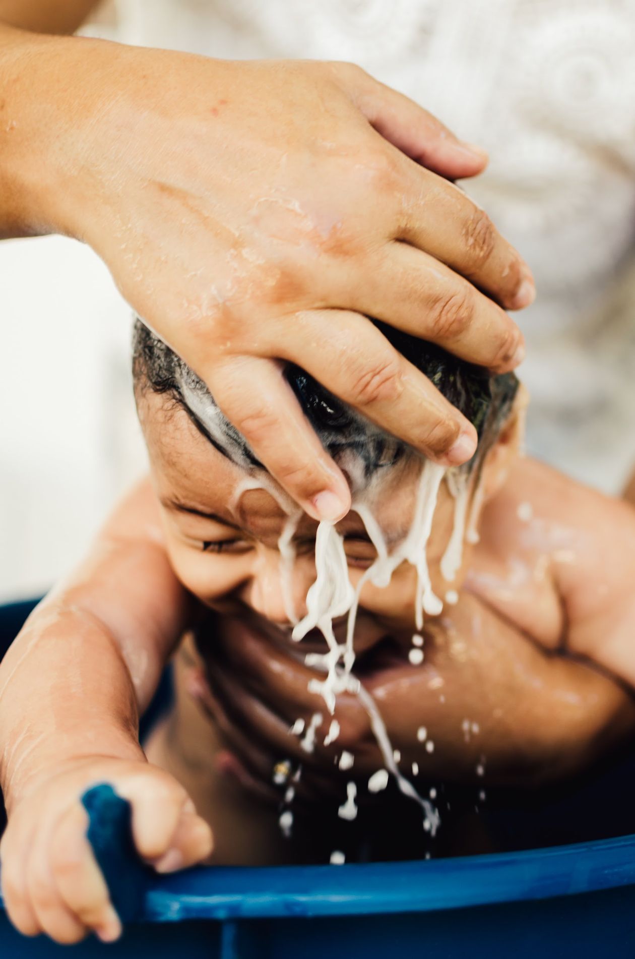 Mãe lavando o cabelo do bebê na hora do banho, contexto de melhor condicionador infantil