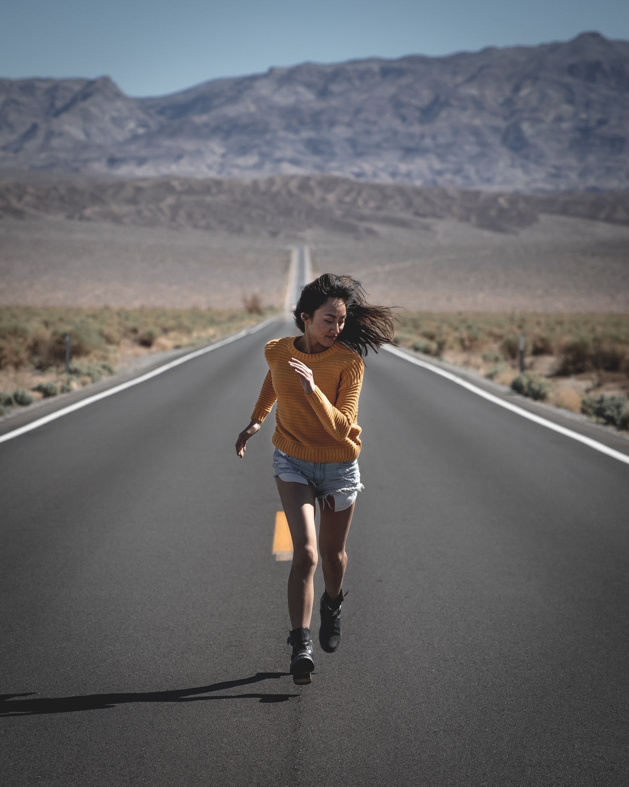 Mulher correndo em estrada com tênis Nike feminino, contexto de tênis nike feminino corrida