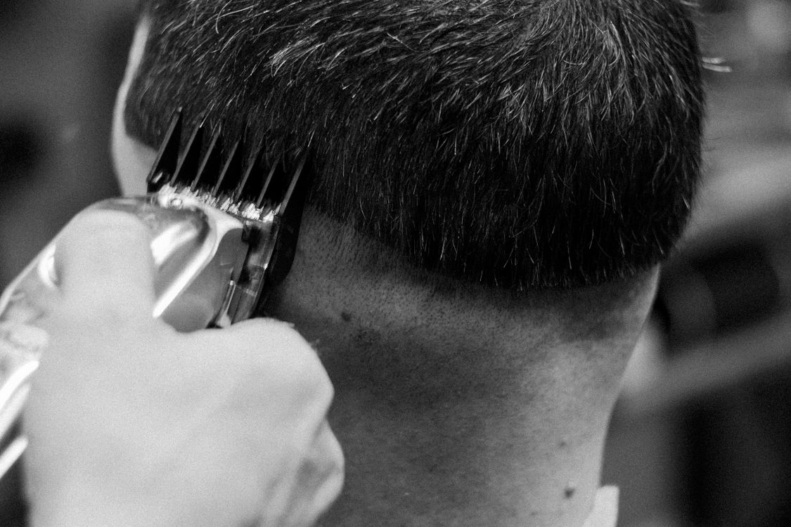 Close-up de corte de cabelo com máquina na barbearia, contexto de máquina Wmark em uso