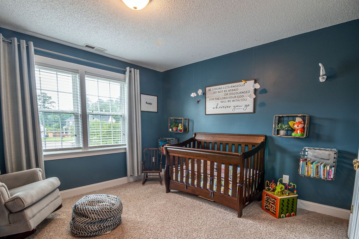 Quarto de bebê com berço de madeira ao lado da janela, contexto de melhor cortina para quarto de bebê