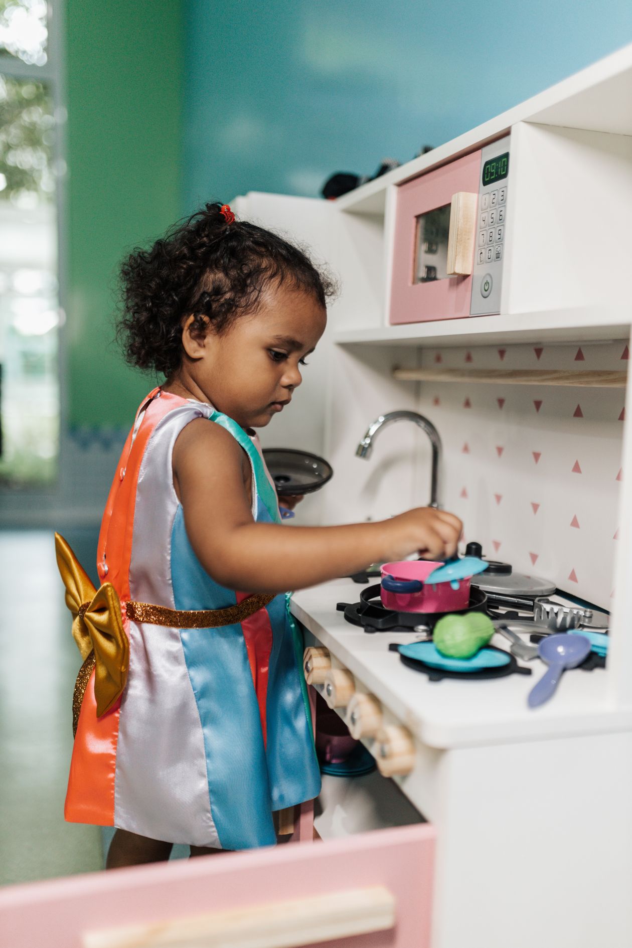 Criança brincando em cozinha infantil de brinquedo, contexto de melhor cozinha infantil