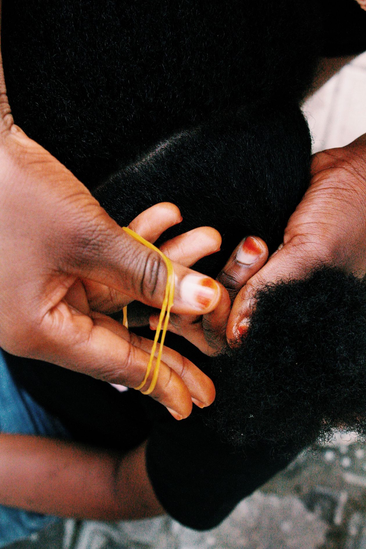 Mãe cuidando do cabelo cacheado da filha em casa, contexto de melhor creme para cabelo cacheado de criança