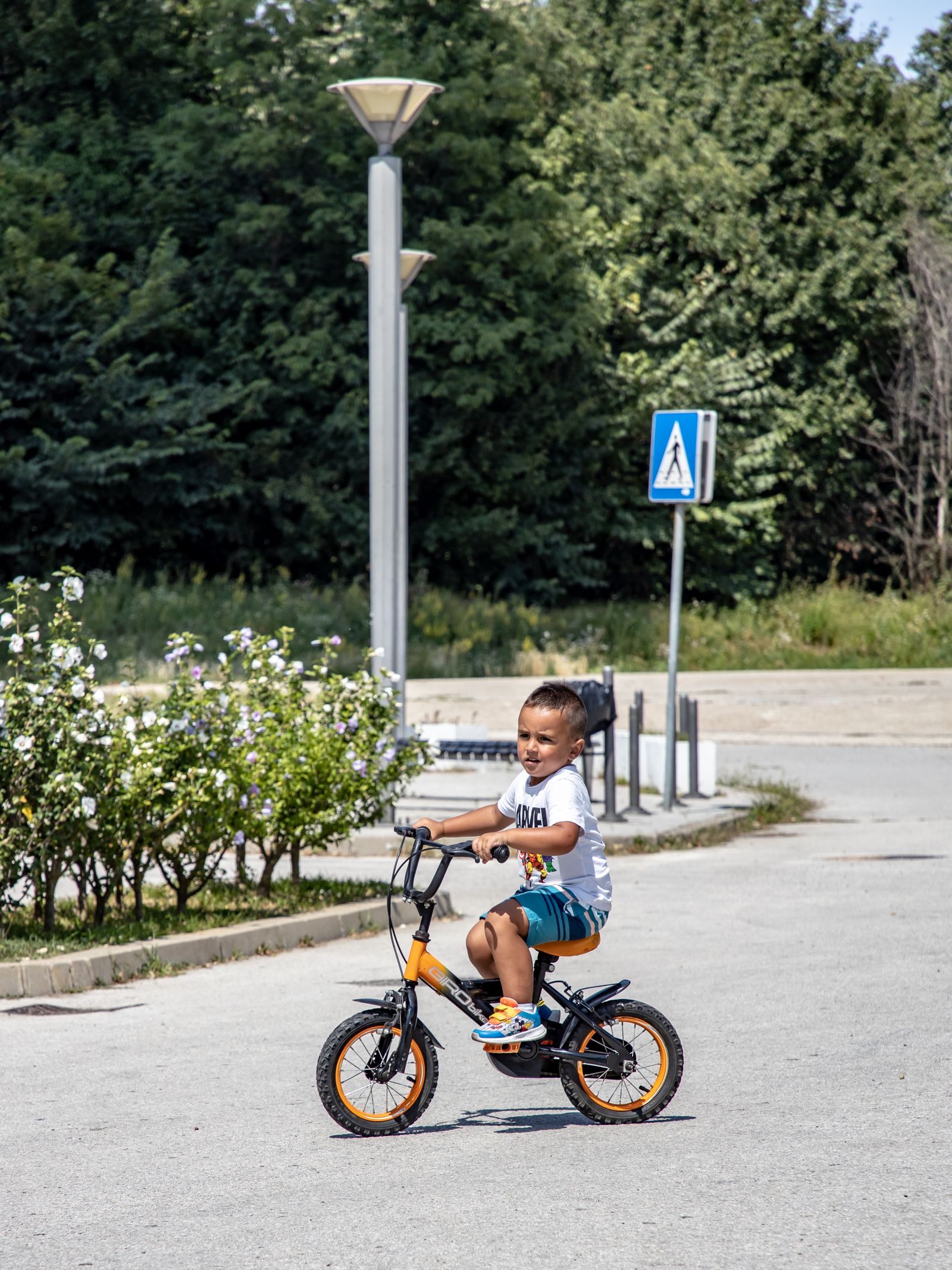 Menino pedalando bicicleta aro 14 em rua de bairro - contexto de uso real da bicicleta infantil