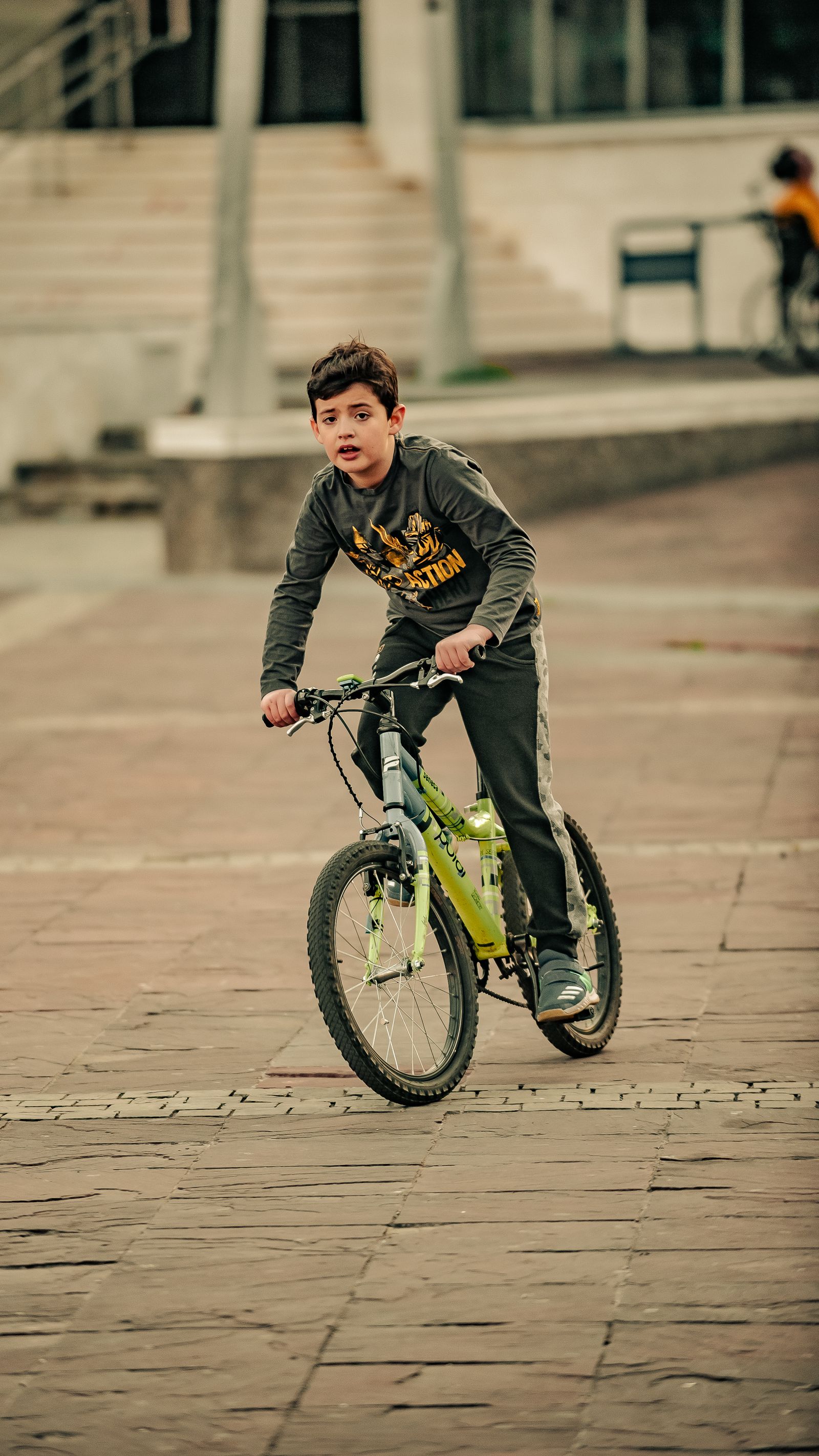 Criança pedalando em rua arborizada - contexto de uso da bicicleta infantil aro 20