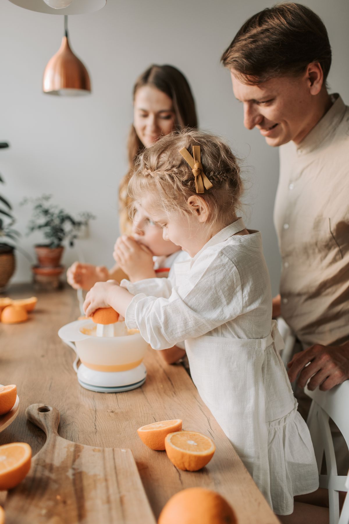 Família preparando suco de laranja, contexto de vitamina C com zinco para criança na alimentação diária