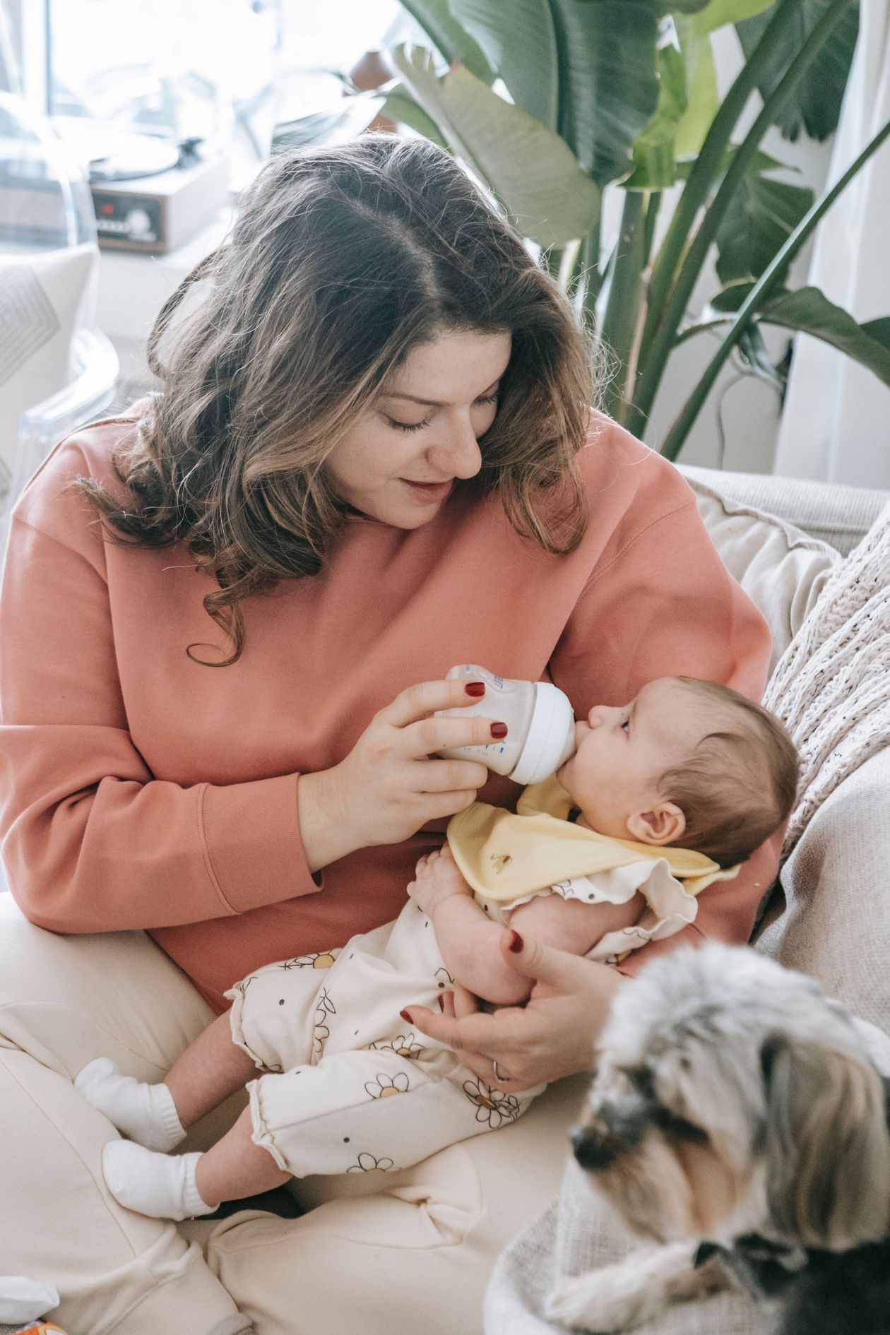 Mãe preparando mamadeira com fórmula infantil para bebê de 0 a 6 meses