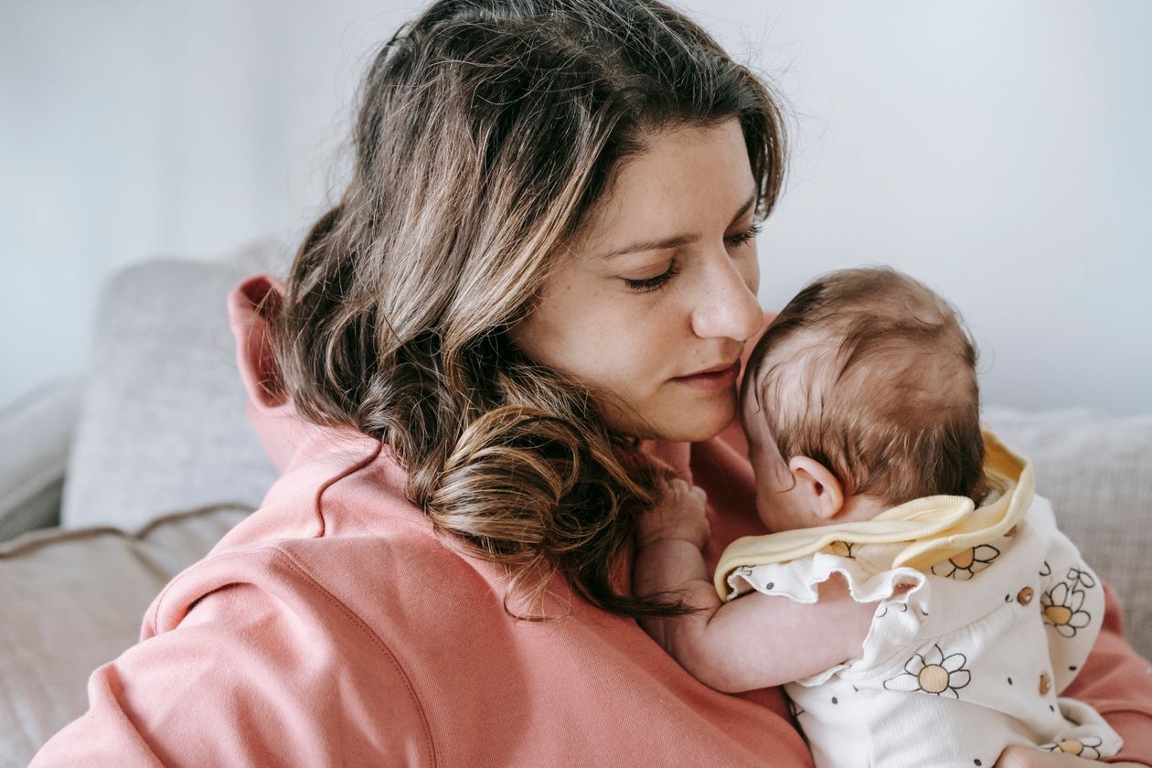 Mãe com o recém-nascido no colo, contexto de fralda pós-parto