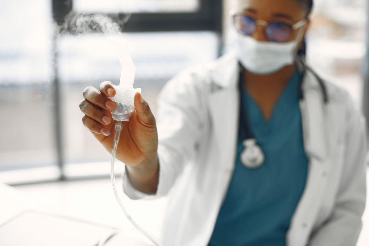 Profissional de saúde segurando um nebulizador, contexto de melhor inalador portátil para criança