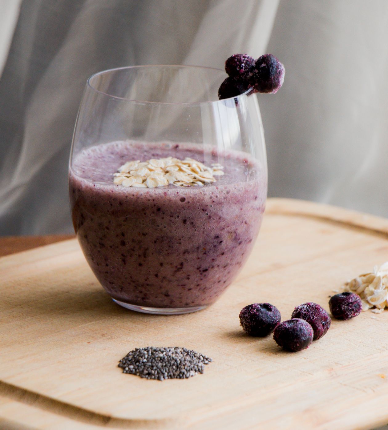 Bebida vegetal servida em copo com aveia e frutas ao lado