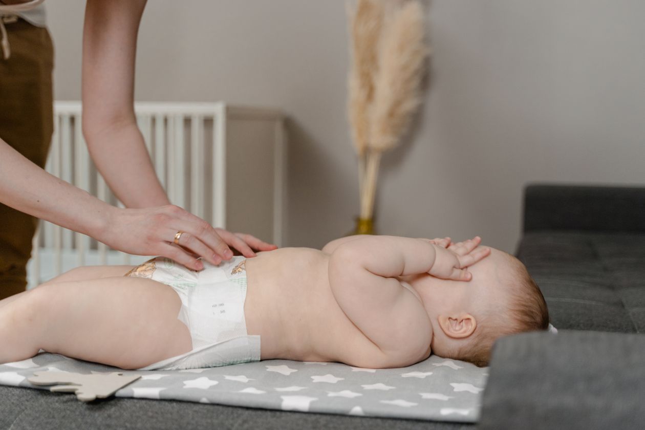 Pessoa trocando a fralda do bebê, contexto de melhor lenço umedecido Pampers