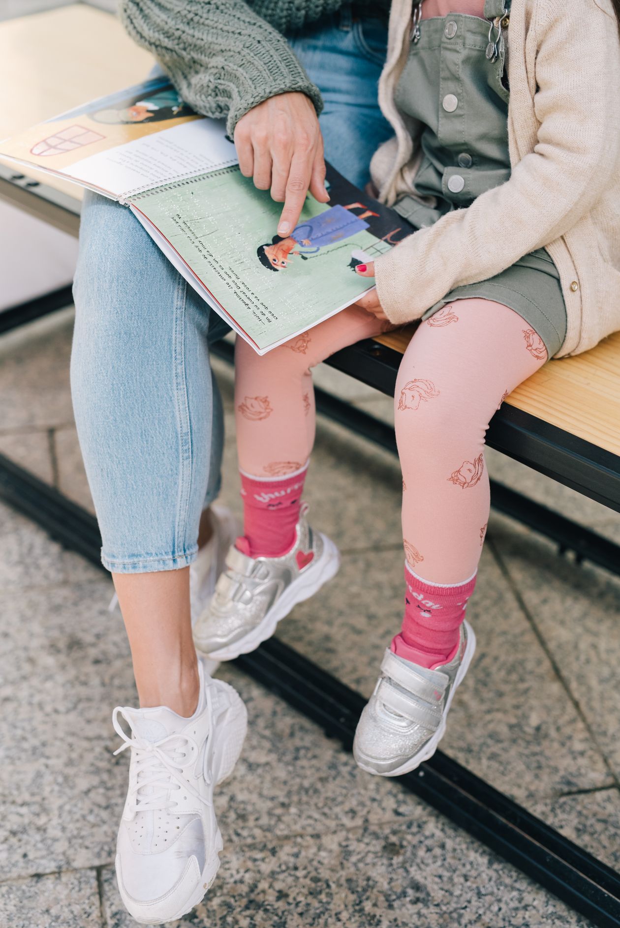 Mãe lendo livro infantil para criança em casa
