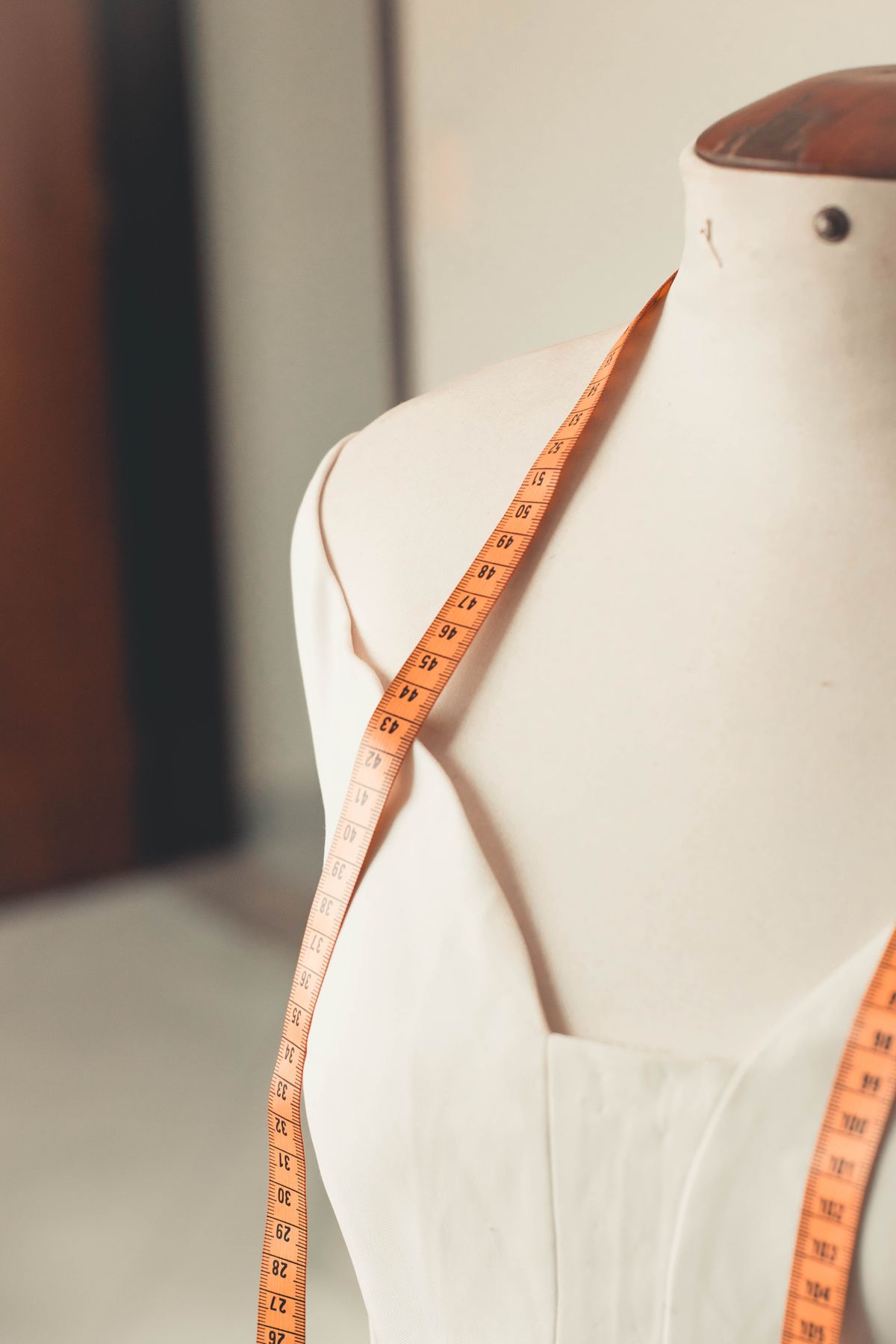 Manequim com fita métrica em ateliê de costura, contexto de tecido para fazer blazer feminino e alfaiataria