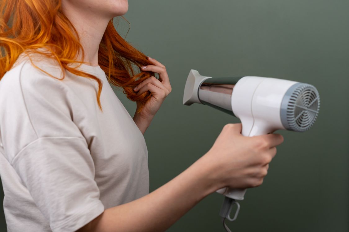 Mão segurando secador de cabelo, contexto de uso diário com tecnologia de íons