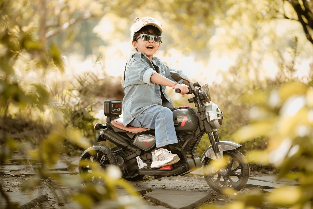 Criança em moto elétrica de brinquedo no parque, contexto de moto elétrica infantil
