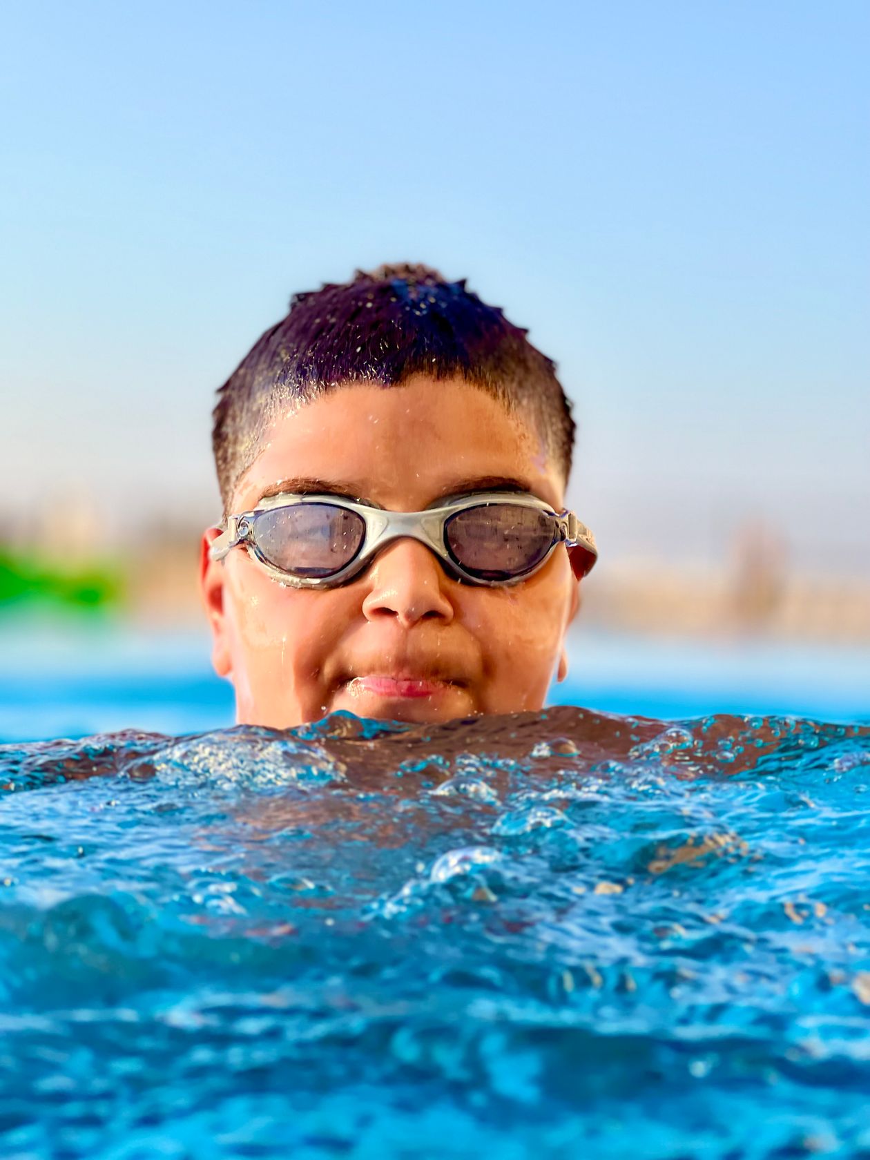 Criança com óculos de natação na piscina, contexto de óculos de natação infantil