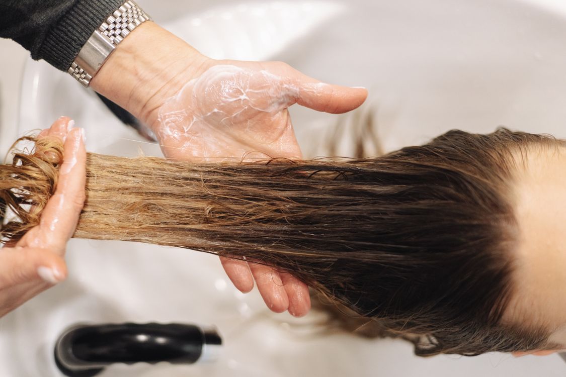 Aplicação de máscara capilar nos fios, contexto de tratamento para cabelo com luzes