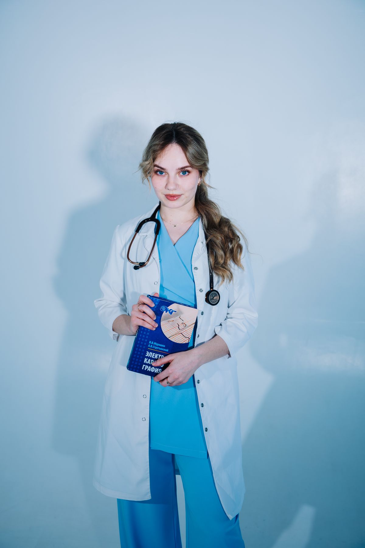 Jovem médica usando jaleco branco em ambiente profissional, contexto de tecido para jaleco feminino