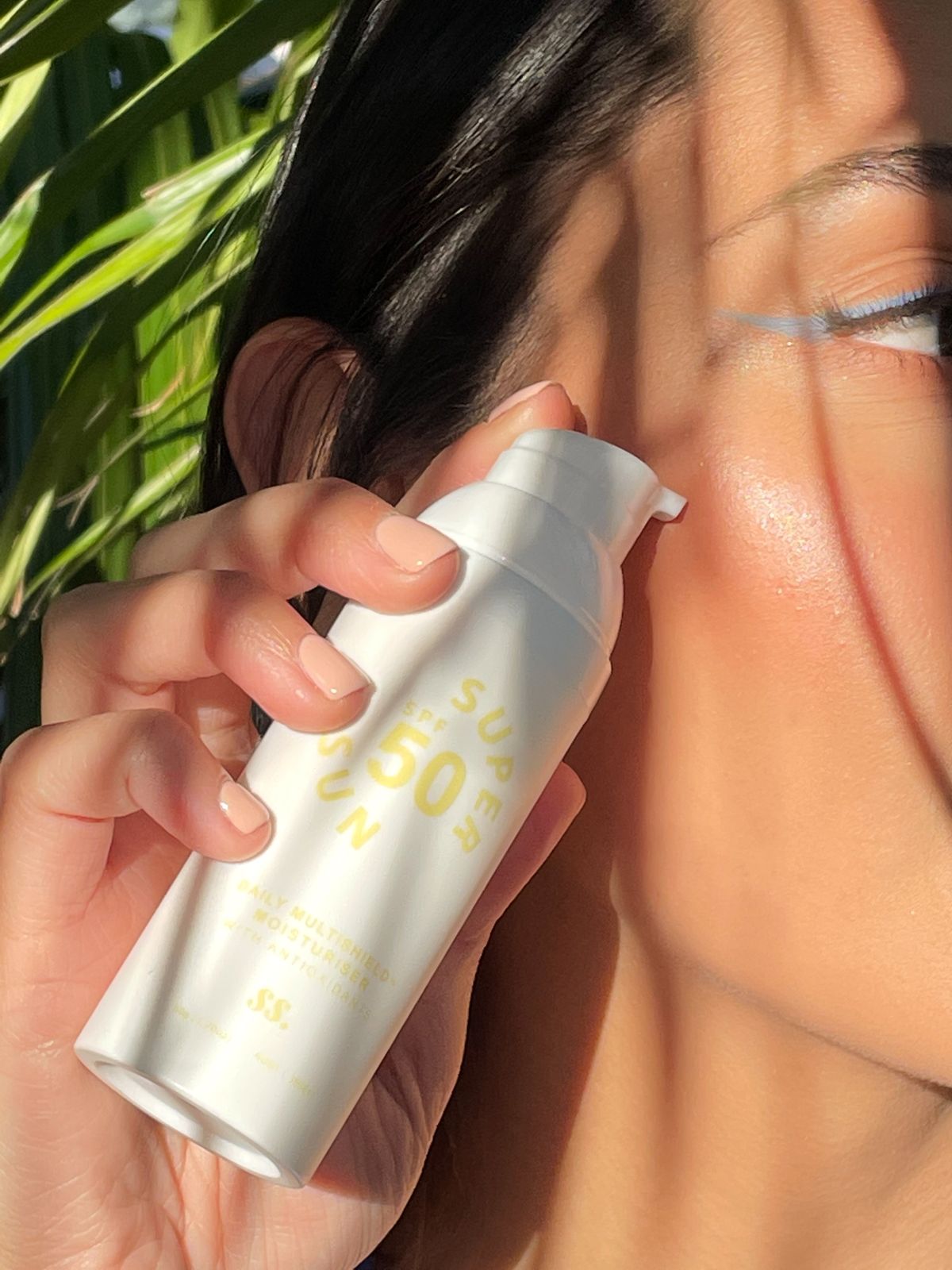 Mulher aplicando protetor solar no rosto ao ar livre, contexto de proteção solar facial e cuidados com a pele