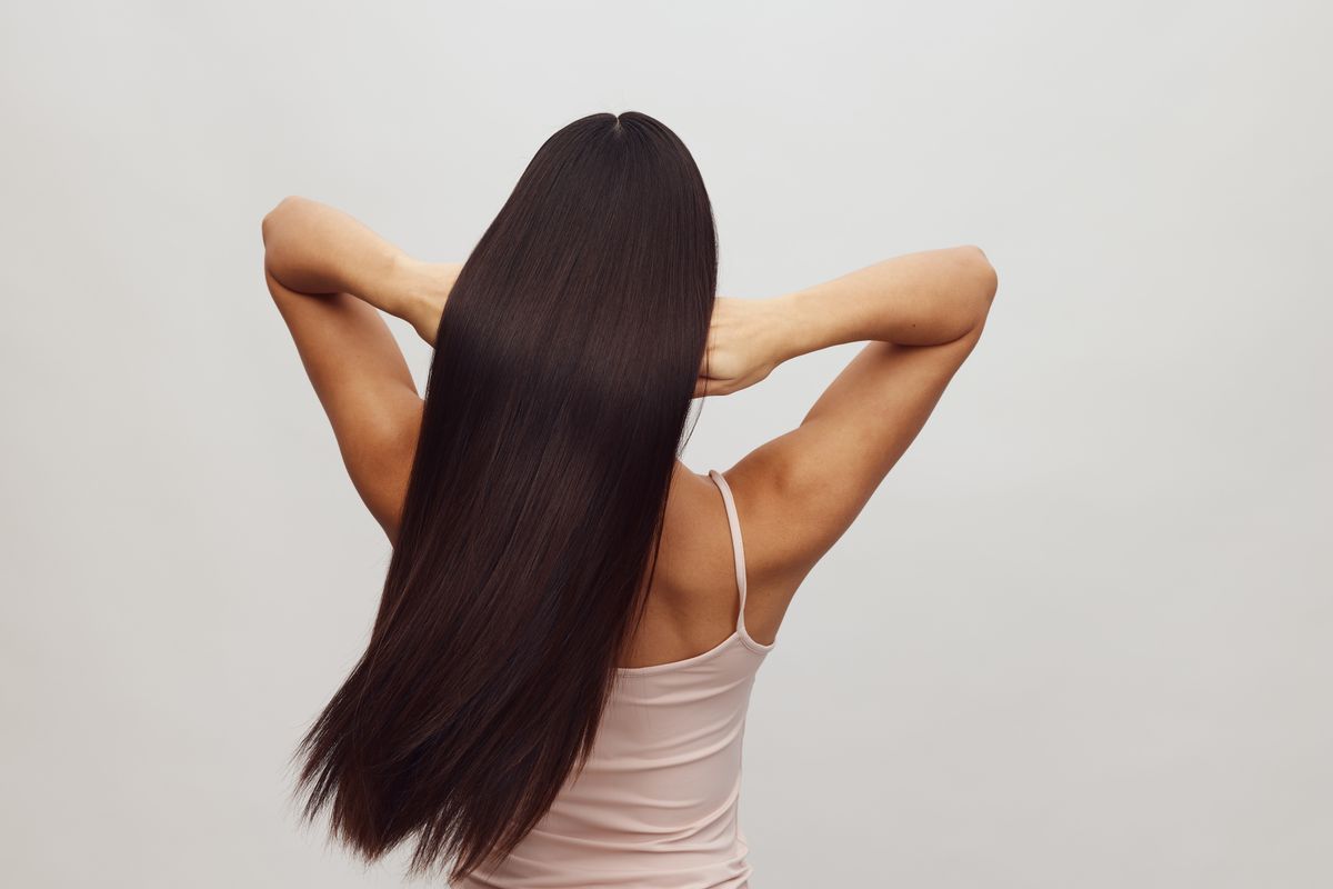 Mulher com cabelo liso e sedoso ao ar livre, contexto de shampoo para cabelo com progressiva