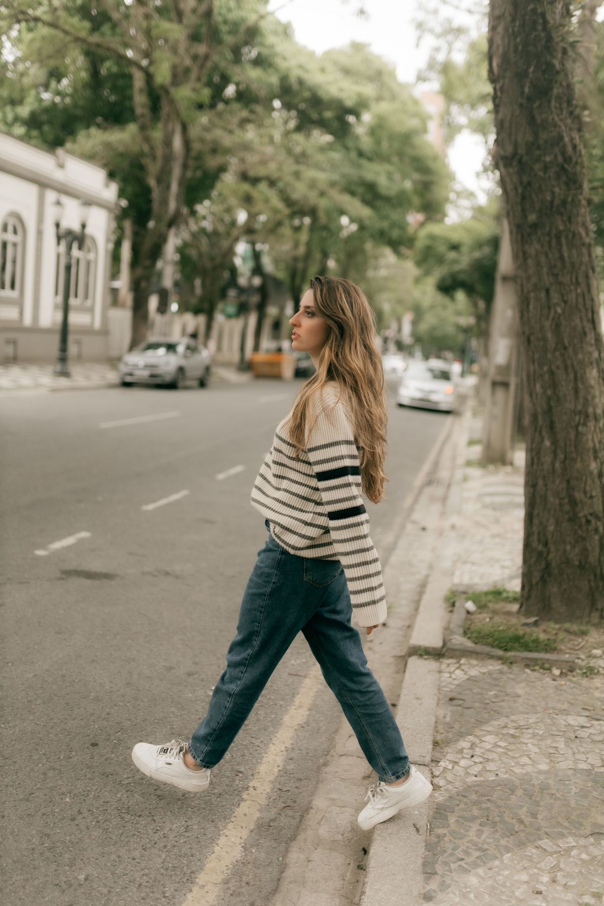 Mulher caminhando pela cidade com tênis casual, contexto de tênis adidas feminino para caminhada