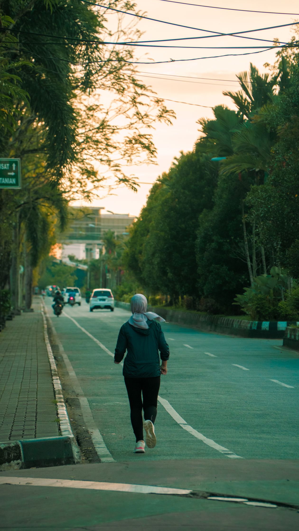 Mulher correndo em rua ao amanhecer com tênis feminino, contexto de tênis com amortecimento feminino