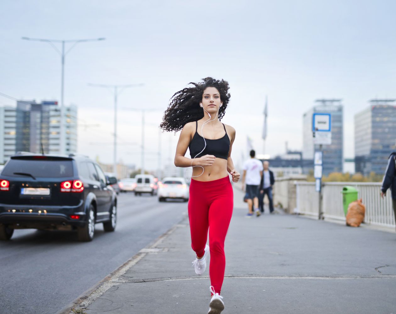Mulher correndo em calçada com tênis Mizuno feminino, contexto de tênis mizuno feminino