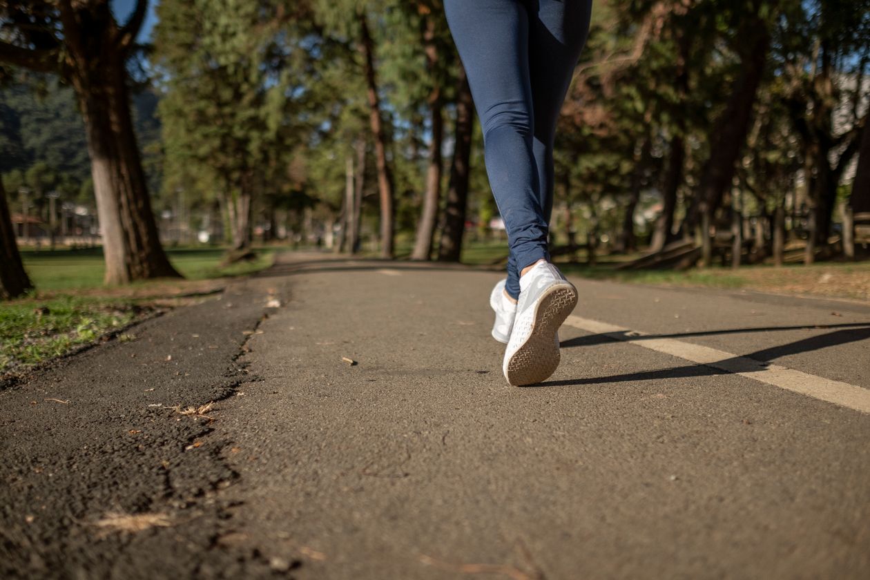 Mulher caminhando na rua com tênis New Balance feminino, contexto de tênis new balance feminino