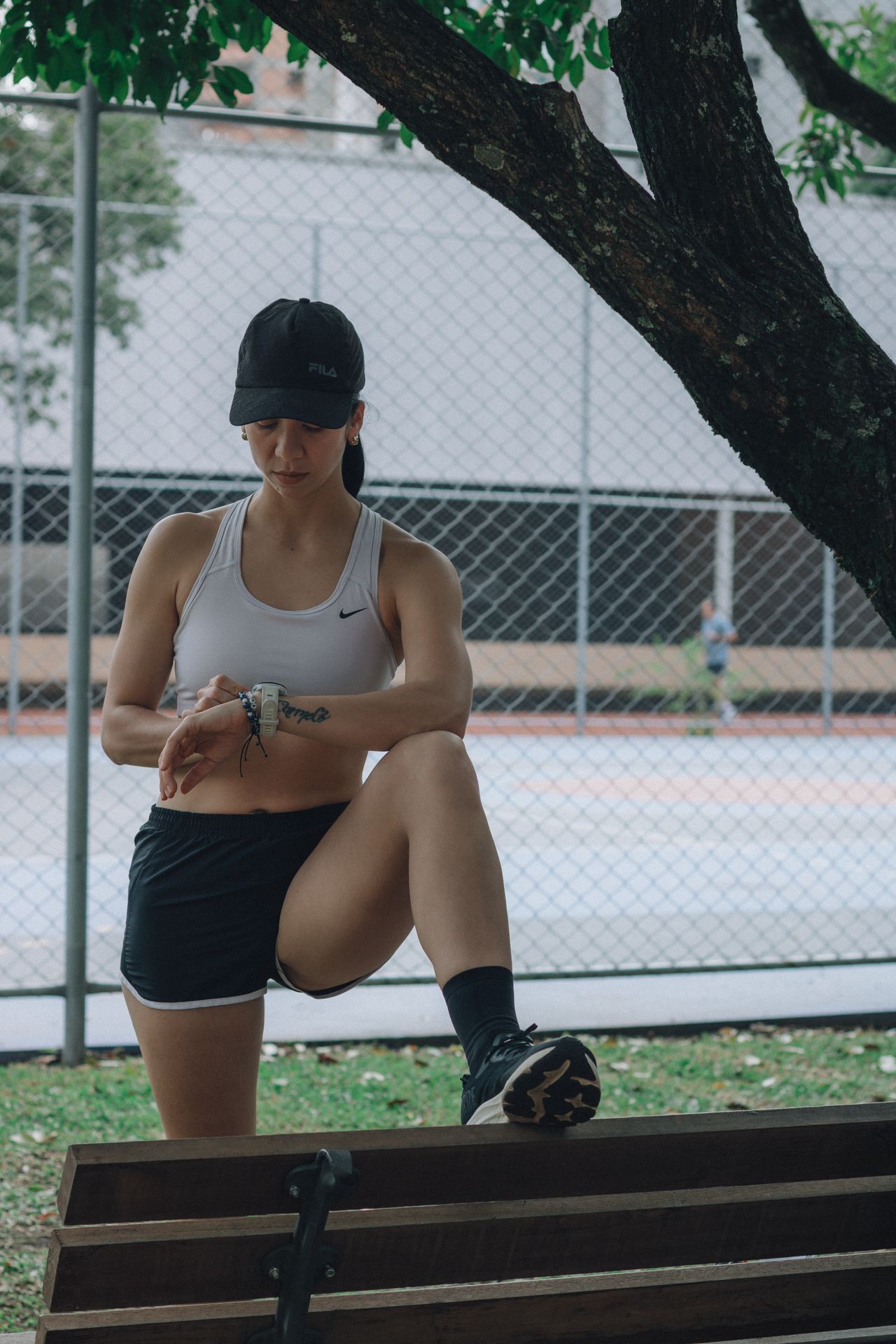 Mulher em roupa esportiva verificando smartwatch durante exercício ao ar livre, contexto de smartwatch Huawei feminino