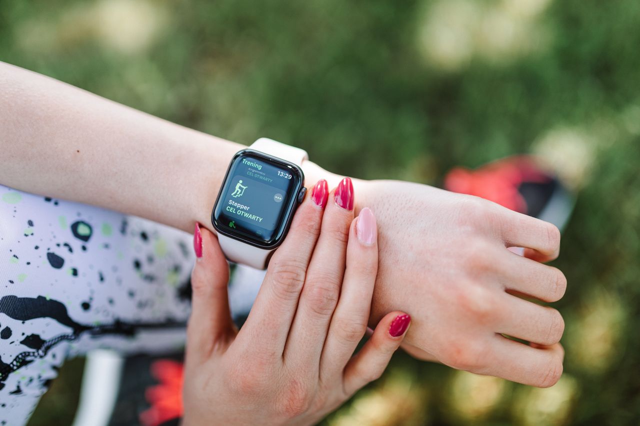 Mulher usando smartwatch em treino ao ar livre, contexto de monitoramento de atividades físicas