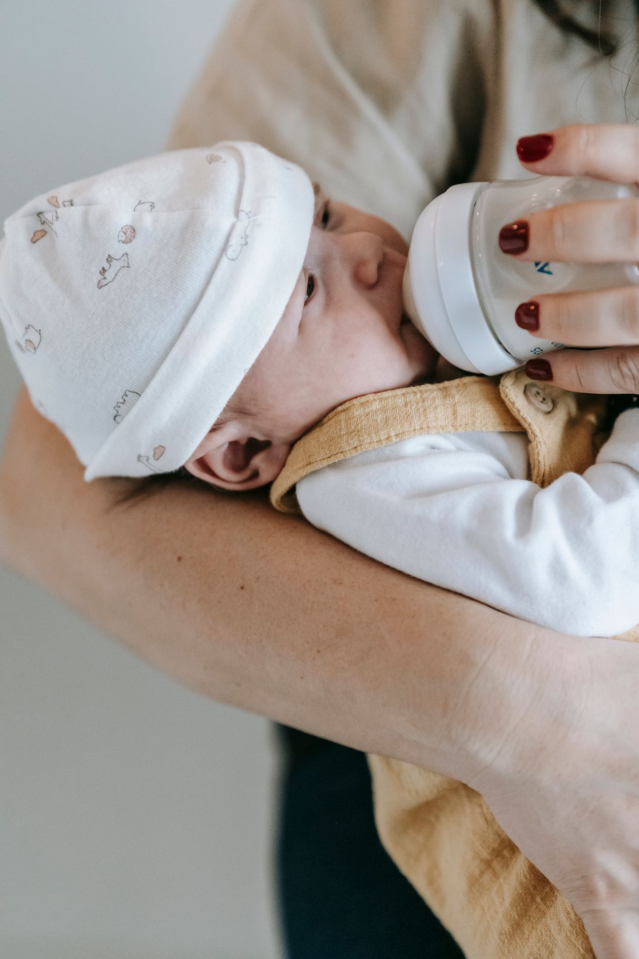 Mãe alimentando recém-nascido com mamadeira, contexto de NAN para RN