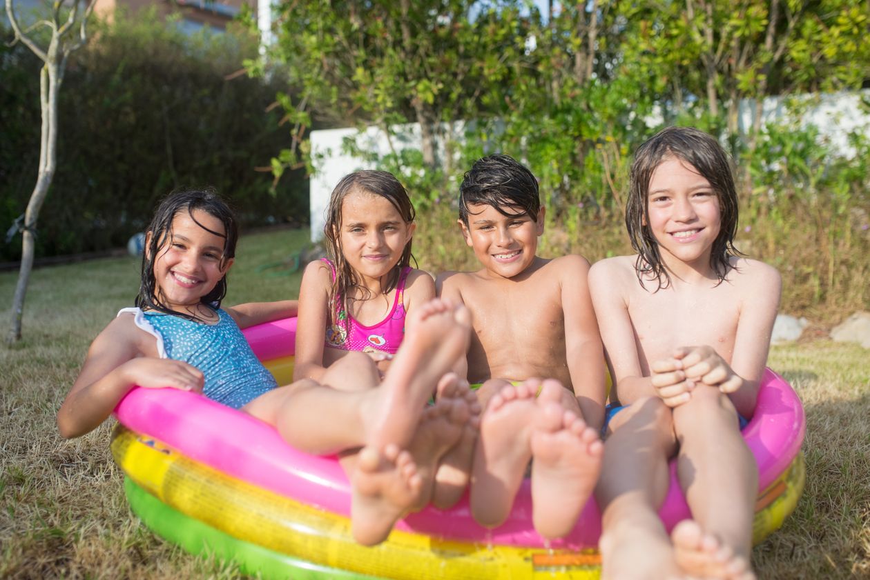 Crianças brincando em piscina infantil inflável no quintal, contexto de melhor piscina infantil