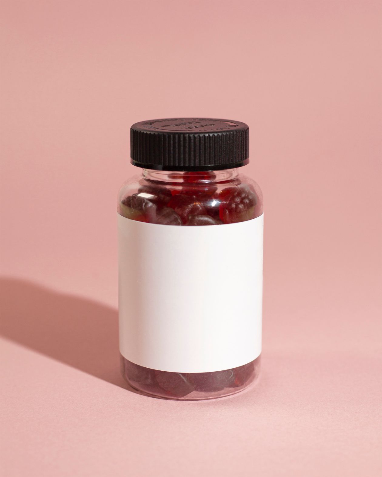 Criança segurando gomas vitamínicas coloridas, contexto de melhor polivitamínico infantil