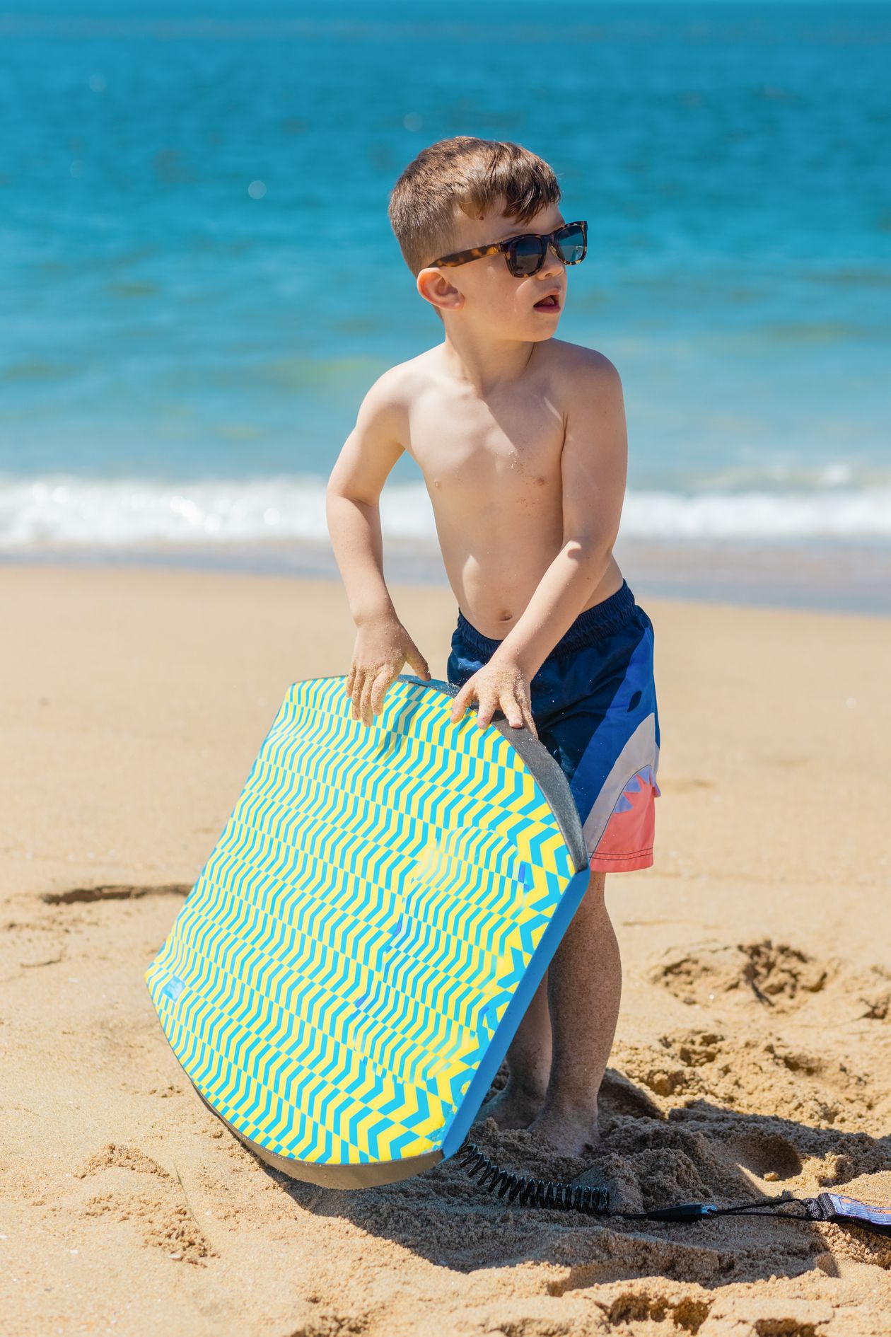 Criança com bodyboard na praia
