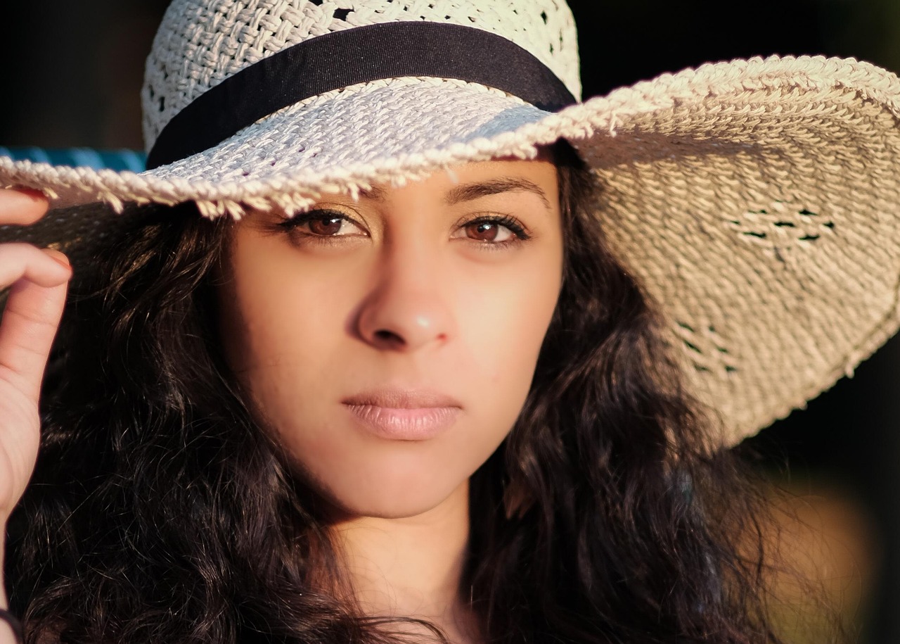 Mulher aplicando protetor solar ao ar livre, contexto de melhor protetor solar em spray ou creme