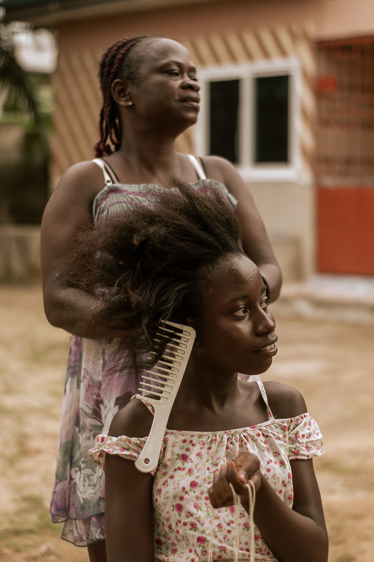 Mãe removendo piolhos do cabelo da filha, contexto de melhor produto para piolho infantil